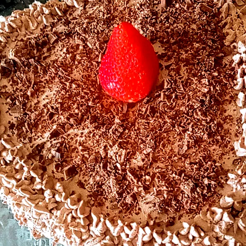 Bolo em formato de coração com raspas de chocolate e morango